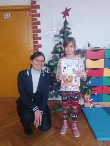 dziewczynka trzyma dyplom za konkurs plastyczny